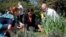 La primera dama junto a su asesor en las iniciativas de alimentación suladable, Sam Kass y una estudiante en el jardín presidencial.