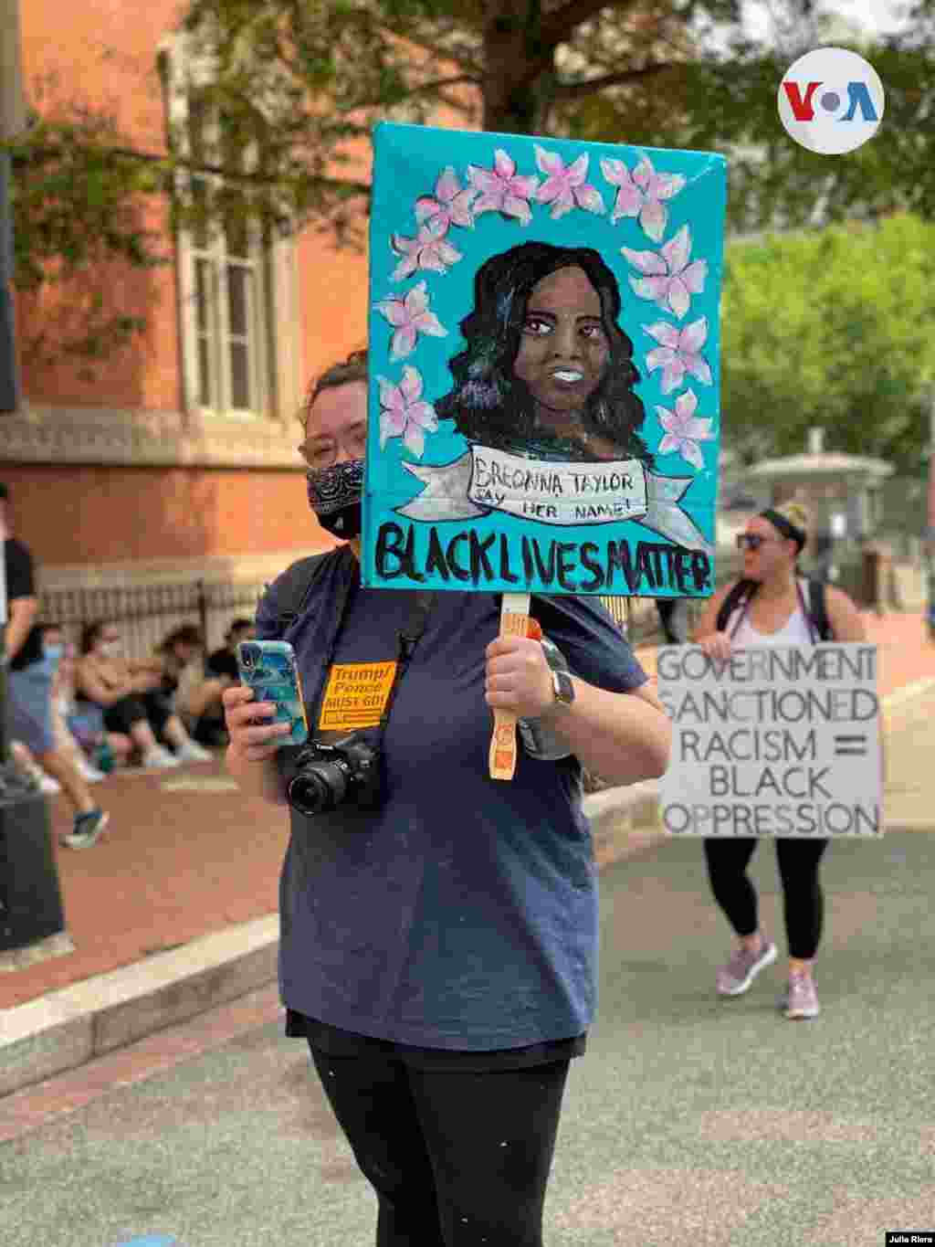 Las vidas negras importan y el racismo sancionado por el gobierno es igual a la opresi&#243;n de los negros, dicen los carteles de dos manifestantes en Washington D.C. el s&#225;bado 6 de junio de 2020.