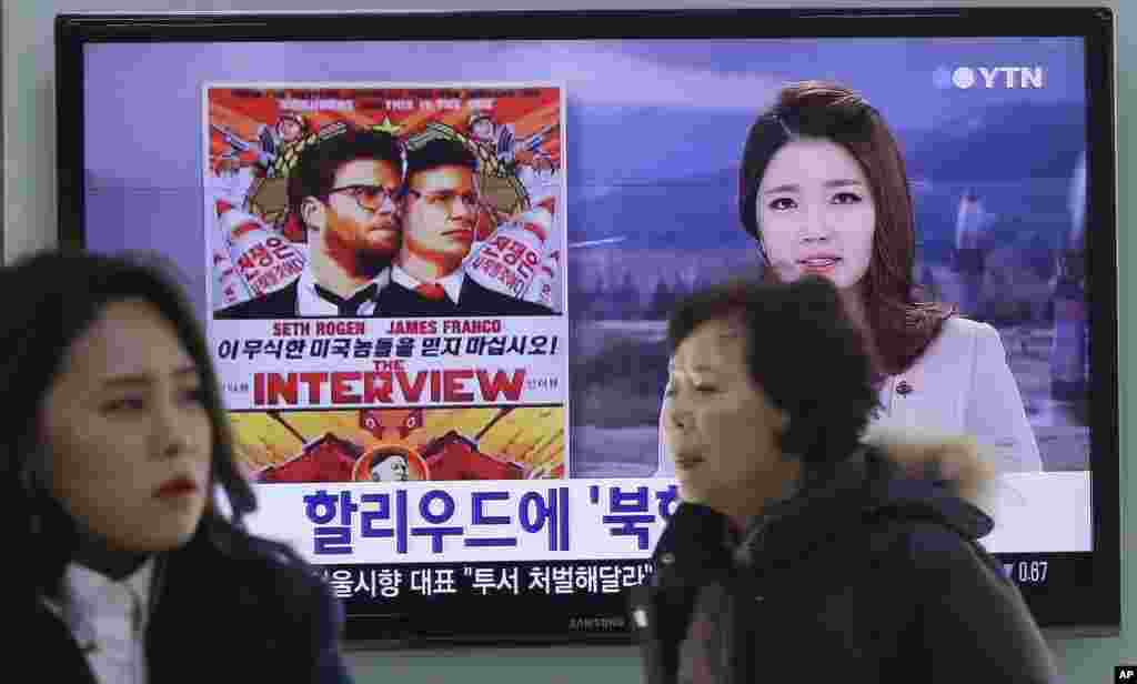 Seorang tentara Korea Selatan melewati televisi yang menayangkan berita mengenai film &quot;The Interview&quot; dari Sony Pictures di stasiun kereta Seoul (22/12). (AP/Ahn Young-joon)