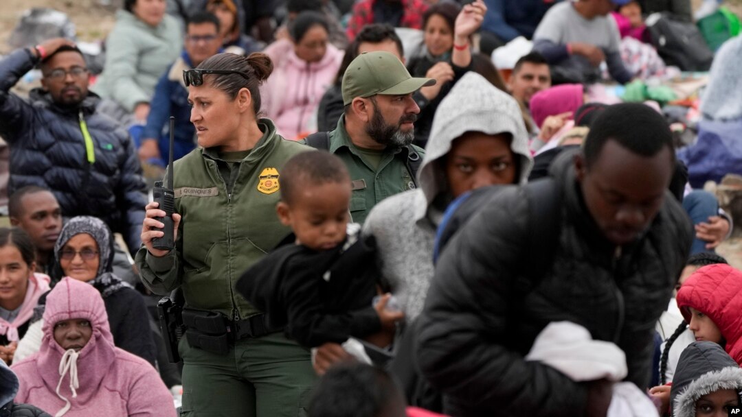 Agentes de la Patrulla Fronteriza de EEUU se mueven entre una multitud de migrantes que han esperado entre dos muros fronterizos durante días para solicitar asilo, el viernes 12 de mayo de 2023, en San Diego. (Foto AP/Gregory Bull)