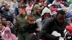 Agentes de la Patrulla Fronteriza de EEUU se mueven entre una multitud de migrantes que han esperado entre dos muros fronterizos durante días para solicitar asilo, el viernes 12 de mayo de 2023, en San Diego. (Foto AP/Gregory Bull)