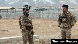 نیروهای امنیتی افغانستان در حال نگهبانی پس از انفجار بمب در پایگاه نظامی غزنی