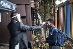 A pupil at the City Kidz Pre &amp; Primary School in the Inner City district in Johannesburg has his temperature measured as he enters the school premises, in South Africa, June 1, 2020.
