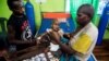 FILE - Family members helps to care for a sick child being treated at the Regional General Hospital (RSUD) in Agats, Asmat District, in the remote region of Papua, Jan. 22, 2018 in this photo taken by Antara Foto. 