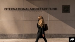 FILE - Signage is seen on the International Monetary Fund building, in Washington, April 5, 2021.