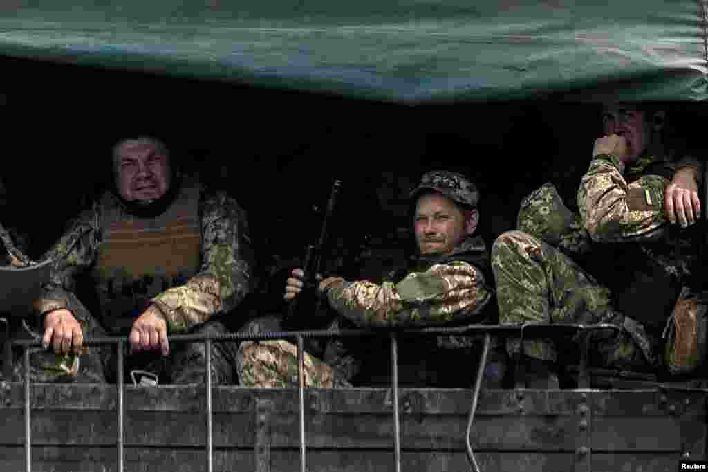 Miembros del ejército ucraniano trasladados en un vehículo militar cerca del poblado de Bakhmut, en la región de Donetsk, en el este de Ucrania, el 21 de mayo de 2022.