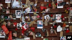 FILE - Photos and notes adorn a wall at the Las Vegas Community Healing Garden in Las Vegas, Oct. 16, 2017. The garden was built as a memorial for the victims of the mass shooting in Las Vegas.