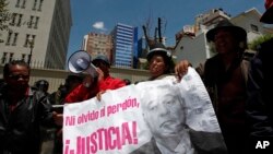 FILE - Protesters hold a banner showing an image of Bolivia's former President Gonzalo Sanchez de Lozada that reads in Spanish "Neither forget nor forgive, Justice!" during a protest demanding his extradition outside the U.S. embassy in La Paz, Bolivia, Wednesday, Oct. 17, 2012.