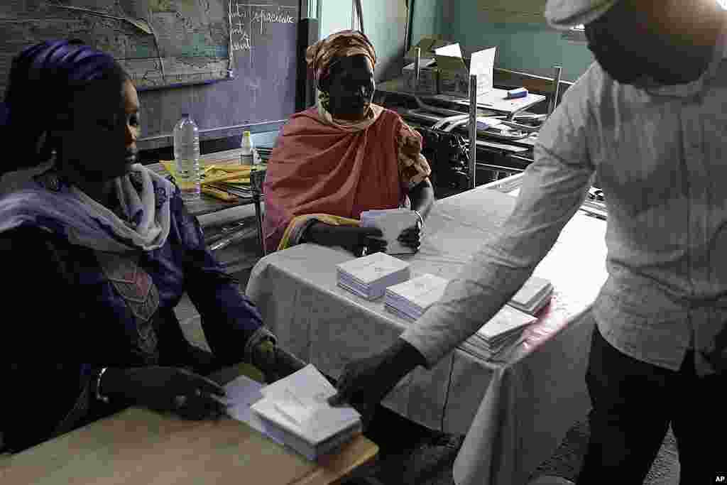 Election workers open ballot envelopes during vote counting at a polling station in the Fass neighborhood of Dakar, March 25, 2012. (AP)