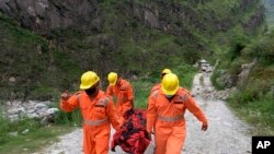 ভারতের জাতীয় দুর্যোগ মোকাবেলা বাহিনীর (NDRF) দেয়া এই ছবিতে দেখা যাচ্ছে কিন্নাউরের ভূমিধ্বসে নিহত একজনের লাশ বহন করছেন এনডিআরএফ সদস্যরা। আগস্ট ১১, ২০২১-এপি 