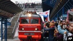 People celebrate the arrival of the train from Russia in Sevastopol, Crimea, after it crossed a bridge linking Russia and the Crimean peninsula Dec. 25, 2019. 