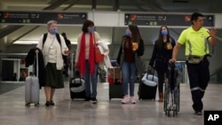 Las personas usan máscaras protectoras como precaución contra la propagación del nuevo coronavirus en el aeropuerto de la Ciudad de México, el viernes.