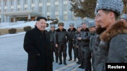 El líder norcoreano, Kim Jong-un conversa con un grupo de pilotos frente al edificio del Comité Central del Partido de los Trabajadores de Corea del Norte.