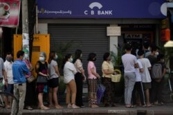 People line up outside a bank branch in Yangon, Myanmar Feb. 1, 2021.