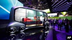 Attendees look at the Toyota e-Pallet concept at CES International, Tuesday, Jan. 9, 2018, in Las Vegas. (AP Photo/Jae C. Hong)