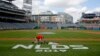 Un jardinero pinta un logo en la grama del Nationals Park en Washington D.C., el 5 de ocutbre de 2019. AP.