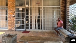 FILE - A man sits outside a closed clinic in Soweto, South Africa, Jan. 30, 2025. President Donald Trump signed an executive order Feb. 7, 2025, that will freeze aid to South Africa because of its effort to address wrongs of its racist apartheid era.