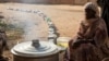 (FILE) A Sudanese woman from a community kitchen as empty pots are seen lined up to receive food, in Omdurman, Sudan, September 19, 2024. 