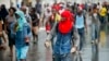 A hooded protester, equipped with stones, takes part in a protest against fuel shortages and to demand the resignation of President Jovenel Moise, in Port-au-Prince, Haiti, Sept. 20, 2019. 