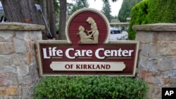 FILE - Image Description A sign at the entrance of the Life Care Center is shown in Kirkland, Wash., near Seattle, March 3, 2020. 