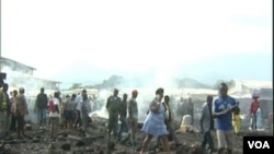 Les passants devant le marché de Limbe réduit en fumée, le 3 avril 2017 