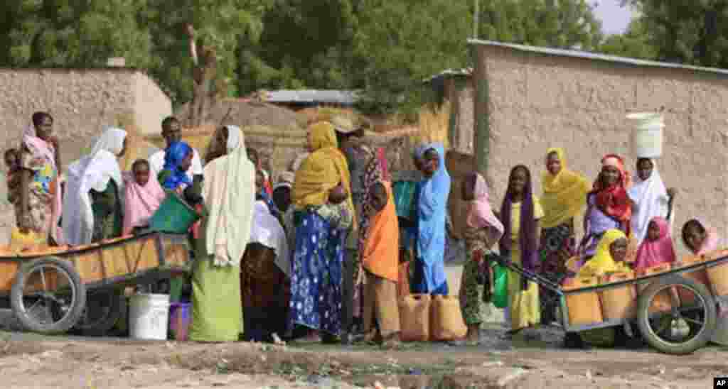 Women wait to draw water from a well in Kerinowa, Nigeria.