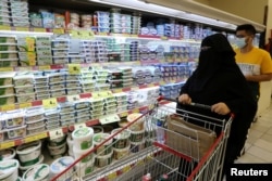 FILE - A Saudi woman looks at the dairy products in a supermarket, after Saudi Arabia's retail stores urged customers to boycott Turkish products, in Riyadh, Saudi Arabia, Oct. 18, 2020.