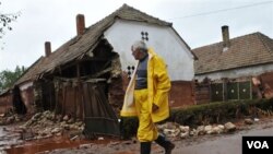 Seorang warga desa di kota kecil Kolontar, Hungaria melewati rumah-rumah yang terkena tumpahan limbah beracun.