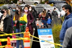 FILE - People line up to be tested for the coronavirus at a free testing site in Seattle, Nov. 18, 2020. With coronavirus cases surging and families hoping to gather safely for Thanksgiving, long lines to get tested have reappeared.