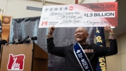 Cheng "Charlie" Saephan menunjukkan cek yang ia terima sebagai salah satu pemenang lotre Powerball senilai $1,3 miliar dalam konferensi pers di Salem, Oregon, pada 29 April 2024. (Foto: AP/Jenny Kane)