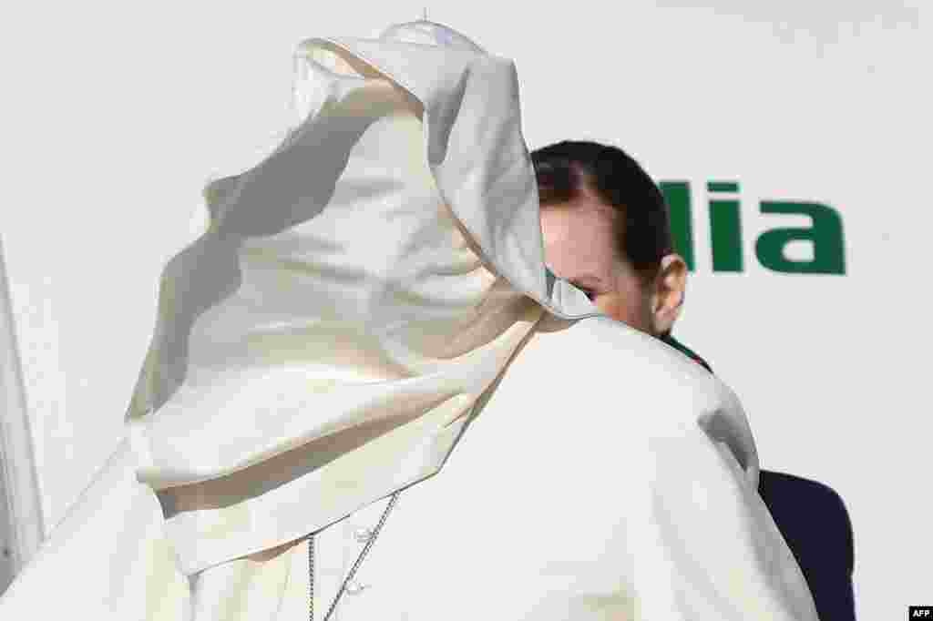 A gale of wind lifts Pope Francis&#39; cassock upon his face as he boards a plane upon his departure for a three-day trip to Romania at Rome&#39;s Fiumicino airport, Italy.