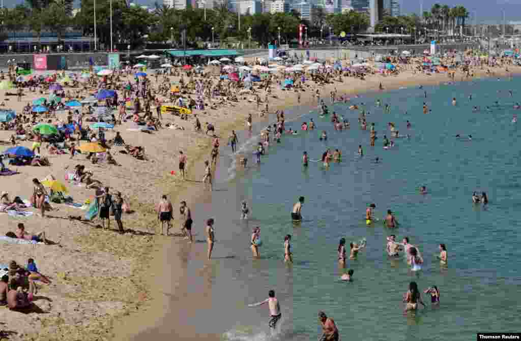 La gente disfruta del clima soleado en una playa de Barcelona, cuando Espa&#241;a reabri&#243; oficialmente sus fronteras en medio del brote de la enfermedad del coronavirus (COVID-19).