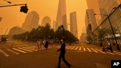 Transeúntes caminan frente al One World Trade Center en medio de la humareda por los incendios forestales de Canadá, el miércoles 7 de junio de 2023, en Nueva York. 