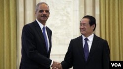 Jaksa Agung AS Eric Holder (kiri) berjabat-tangan dengan pejabat Partai Komunis Tiongkok Zhou Yongkang dalam kunjungan di Beijing, Rabu 20 Oktober 2010.