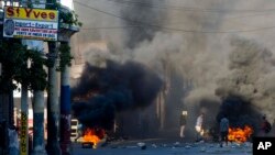 Burning tires and large rocks serve as barricades blocking a road on the third day of a strike and of countrywide protests over allegations of government corruption, in Port-au-Prince, Haiti, Nov. 20, 2018. 