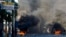 Burning tires and large rocks serve as barricades blocking a road on the third day of a strike and of countrywide protests over allegations of government corruption, in Port-au-Prince, Haiti, Nov. 20, 2018. 
