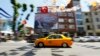 FILE - A yellow taxi drives past a poster depicting Turkey's Prime Minister Tayyip Erdogan in Istanbul.
