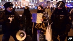 Полиция задерживает демонстранта с плакатом в Москве, Россия, 24 февраля 2022 года