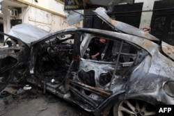 A child walks behind a car destroyed in an overnight Israeli strike on Jenin in the occupied West Bank on Feb. 23, 2024.