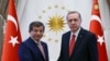 FILE - Turkish President Recep Tayyip Erdogan, right, and Prime Minister Ahmet Davutoglu shake hands as they pose for a photograph during a final farewell in Ankara, May 19, 2016.