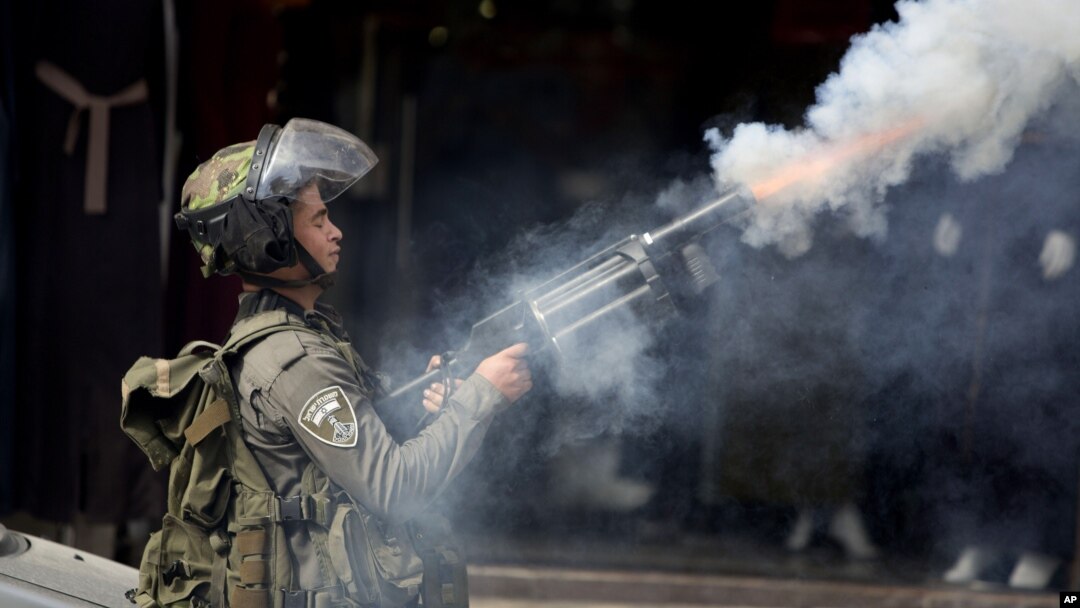 Seorang polisi Israel menembakkan gas air mata ke arah demonstran Palestina di kota al-Ram, utara Yerusalem, Kamis (22/10).