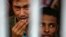 FILE - Rohingya people from Myanmar, who were rescued from human traffickers, react from inside a communal cell at Songkhla Immigration Detention Centre, near Thailand's border with Malaysia.