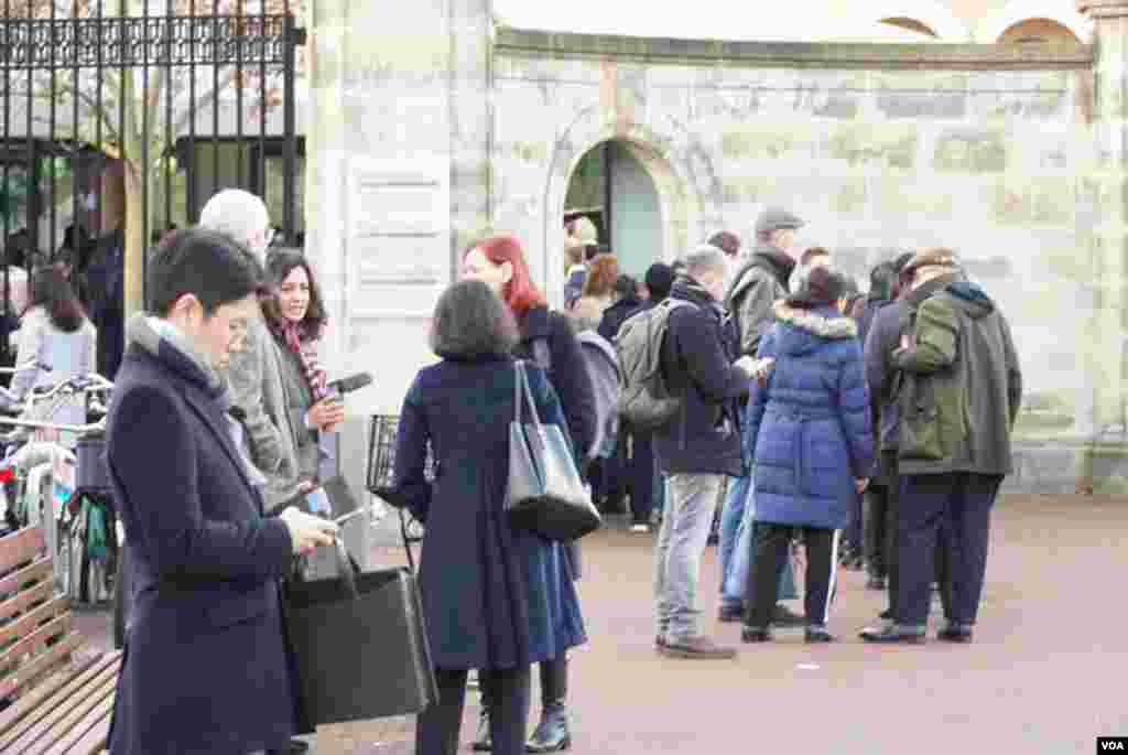 Journalists and members of the public queue