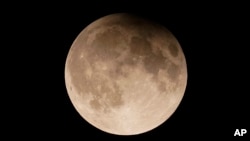 FILE - A supermoon with a partial lunar eclipse rises over Lake Michigan in Chicago, Sept. 17, 2024. (AP Photo/Kiichiro Sato, File)