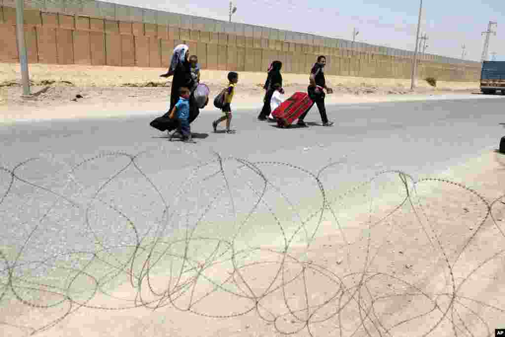 Iraqi refugees from Syria arrive at the border crossing by the Iraqi town of Qaim