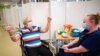 Margaret Keenan, 90, is applauded by staff as she returns to her ward after becoming the first patient in the UK to receive the Pfizer-BioNTech COVID-19 vaccine, at University Hospital, Coventry, England, Dec. 8, 2020. 