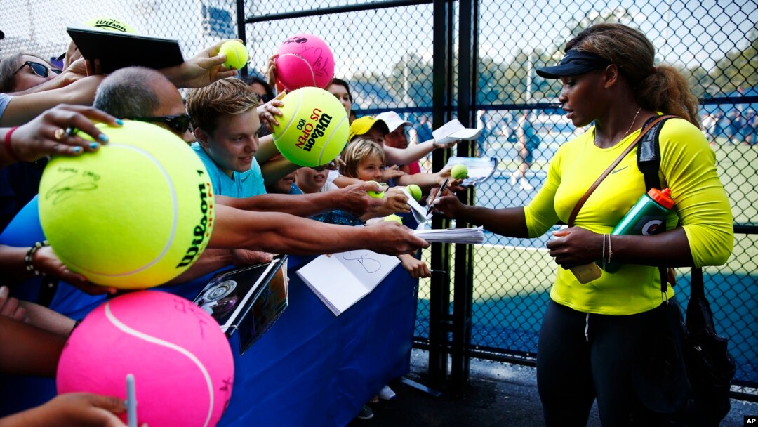 Serena Williams memberi tanda tangan pada para penggemar usai sesi latihan dalam turnamen AS Terbuka di New York (24/8). (AP/Matt Rourke)