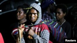 Warga Papua menaiki bus untuk proses evakuasi oleh TNI dan Polisi setelah bentrokan dengan kelompok separatis di Mimika, Papua, 8 Maret 2020. (Foto: Antara via Reuters)