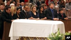 Family, including mother Roxanna Green, third from right, father John Green, second from right, and son Dallas Green, right, kneel in prayer behind the casket during the funeral of his daughter, 9-year-old Christina Taylor Green, in Tucson, Arizona, 13 Ja