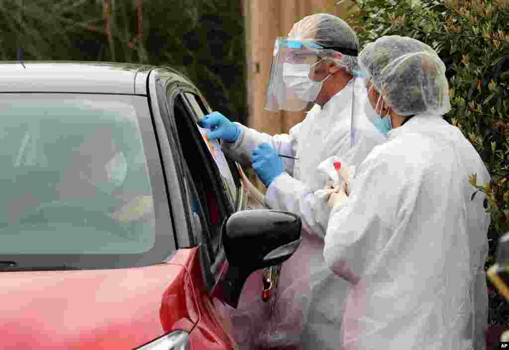 کارکنان پزشکی در حال گرفتن تست علائم کووید۱۹ از راننده یک ماشین در یک مرکز تست در ماشین در جنوب فرانسه